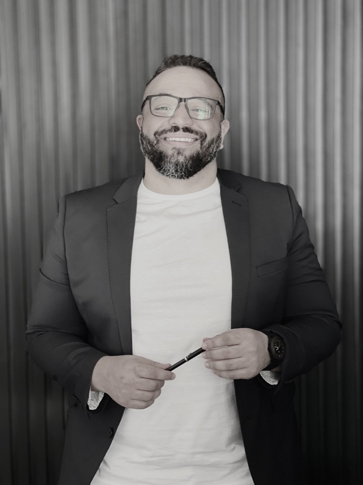 Mateus Felipe, de blazer escuro, sorrindo